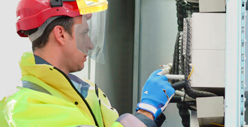 Electrical technician working in safety gear 